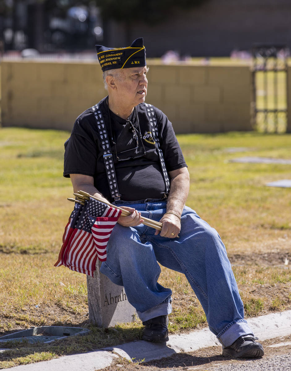 Army veteran Howard Greenspon takes a moment's rest while planting American flags on veteran's ...