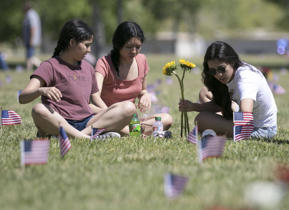Jen Hernandez, right, and her sister, Alexandra, center, visit the grave site of their brother ...