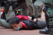 A protester is detained by riot police during a demonstration against Beijing's national securi ...