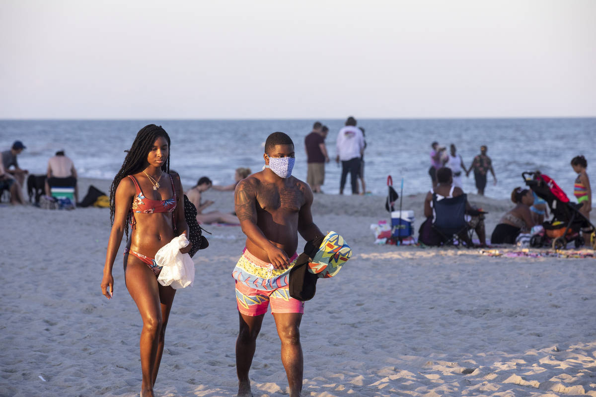 Sunbathers catch the last rays of evening light, amid the coronavirus pandemic, Saturday, May 2 ...