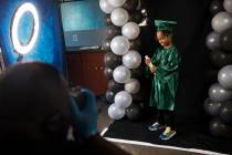 Dr. Dillard A. Scott takes a photo of Messiah Harris, 6, for his kindergarten graduation at Mr. ...