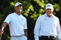 FILE - In this April 3, 2018, file photo, Tiger Woods, left, and Phil Mickelson share a laugh o ...