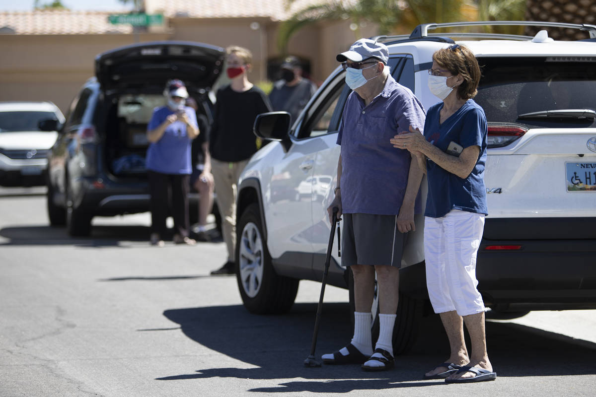 Friends and neighbors watch as Bob Altomondo, who played trumpet in the Navy, play TAPS outside ...