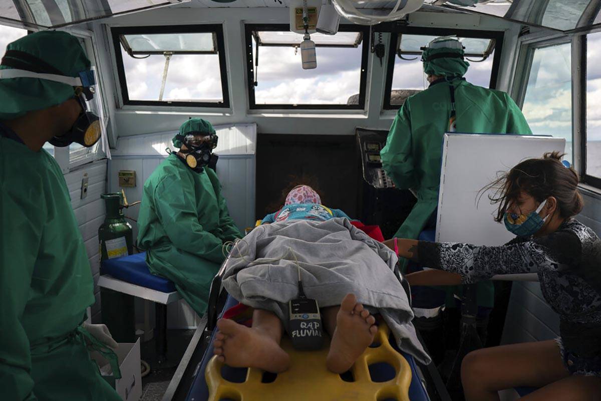 Fluvial emergency workers transfer by boat a 10-year-old suspected COVID-19 patient from a rive ...