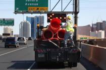 Crews work to remove orange safety barrels along Interstate 15 near the Sahara Avenue exit on M ...