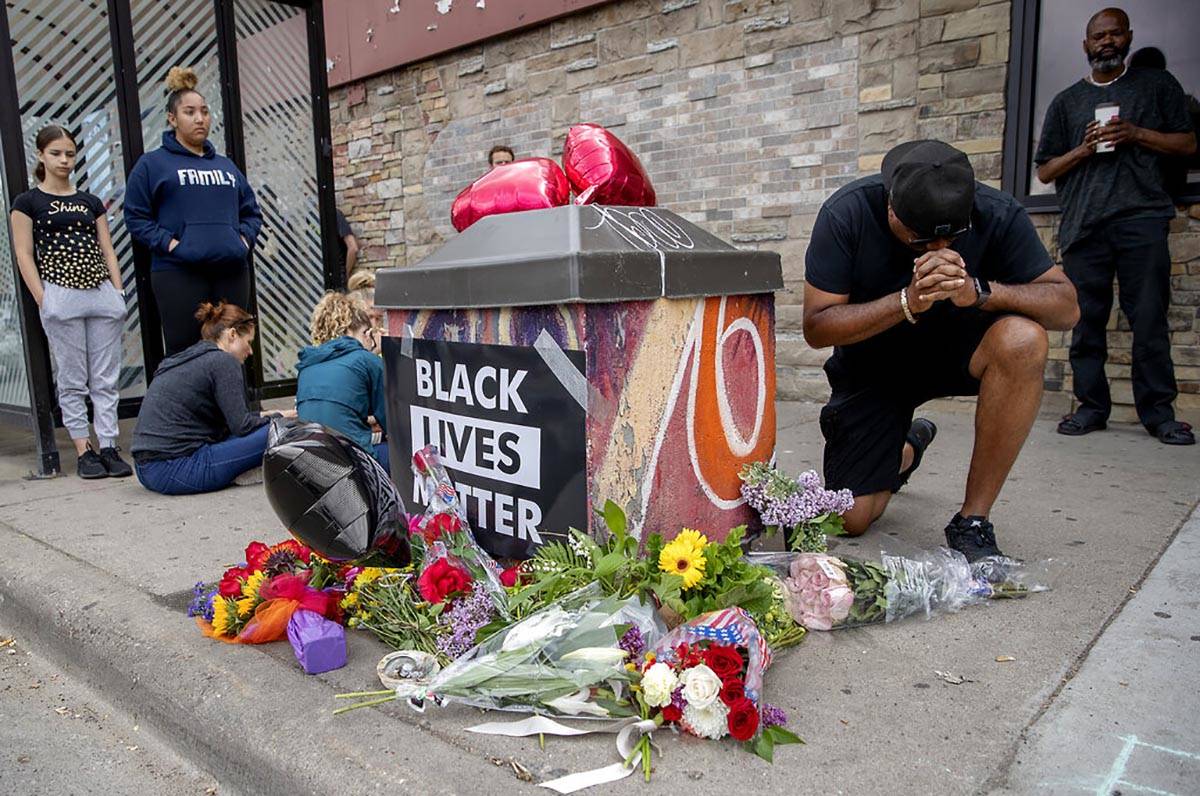 People gather and pray around a makeshift memorial, Tuesday, May 26, 2020, in Minneapolis, near ...
