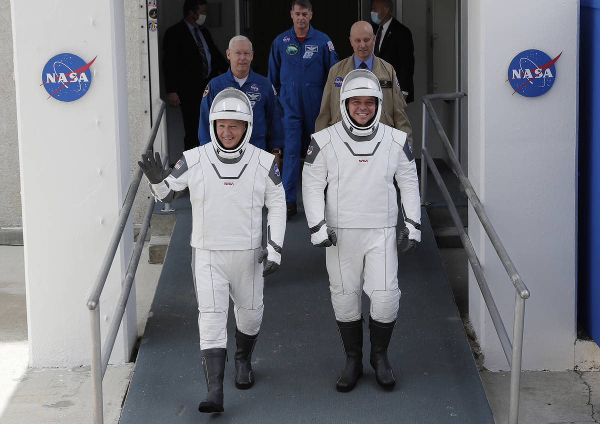 NASA astronauts Douglas Hurley, left, and Robert Behnken wave as they walk out of the Neil A. A ...