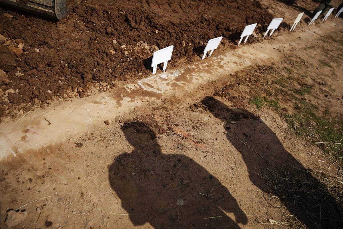 In this April 7, 2020, file photo, temporary placards mark the plots of those recently buried, ...