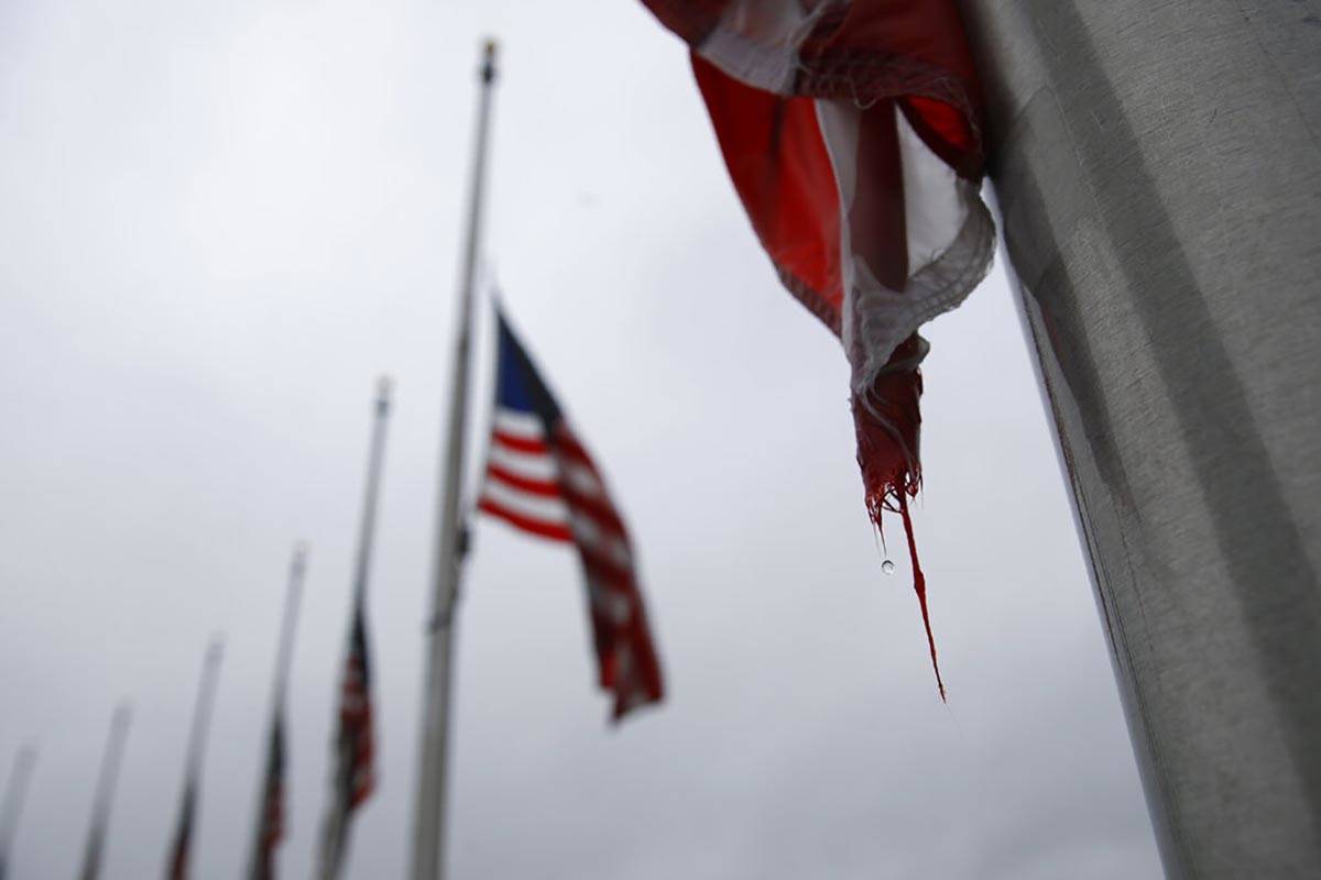 In this May 22, 2020, file photo, a raindrop falls from an American flag at half-staff at the W ...