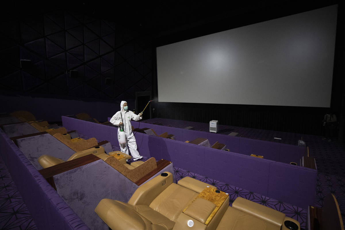 A worker sprays disinfectant as a precaution against the new coronavirus at Quartier Cineart mo ...