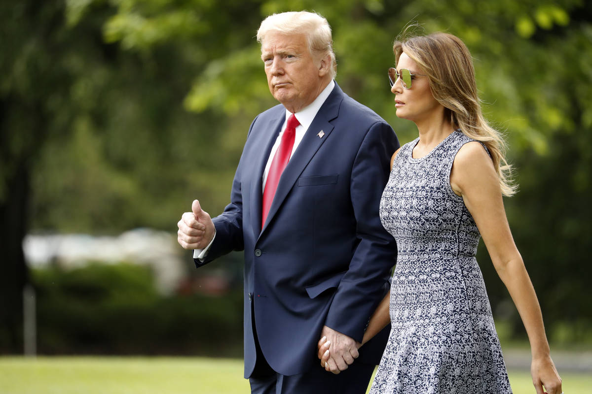 President Donald Trump and first lady Melania Trump walk on the South Lawn of the White House i ...