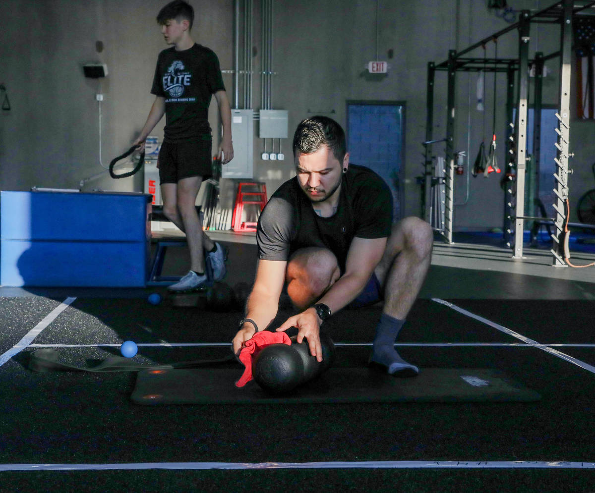 Brian Lee, member of The Gym Las Vegas, disinfects his mat, the first morning on the facility's ...