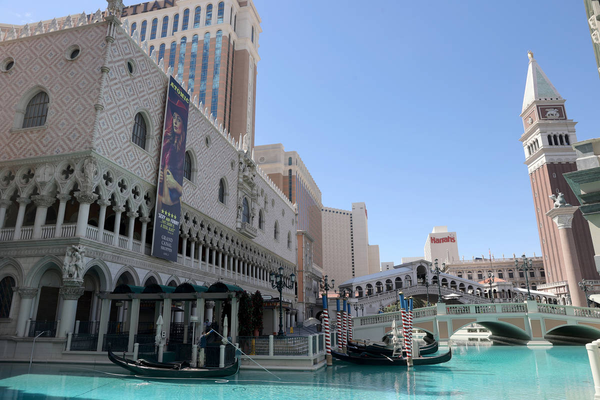 Pool maintenance worker Armando Felix cleans the outdoor canal at The Venetian on the Strip in ...
