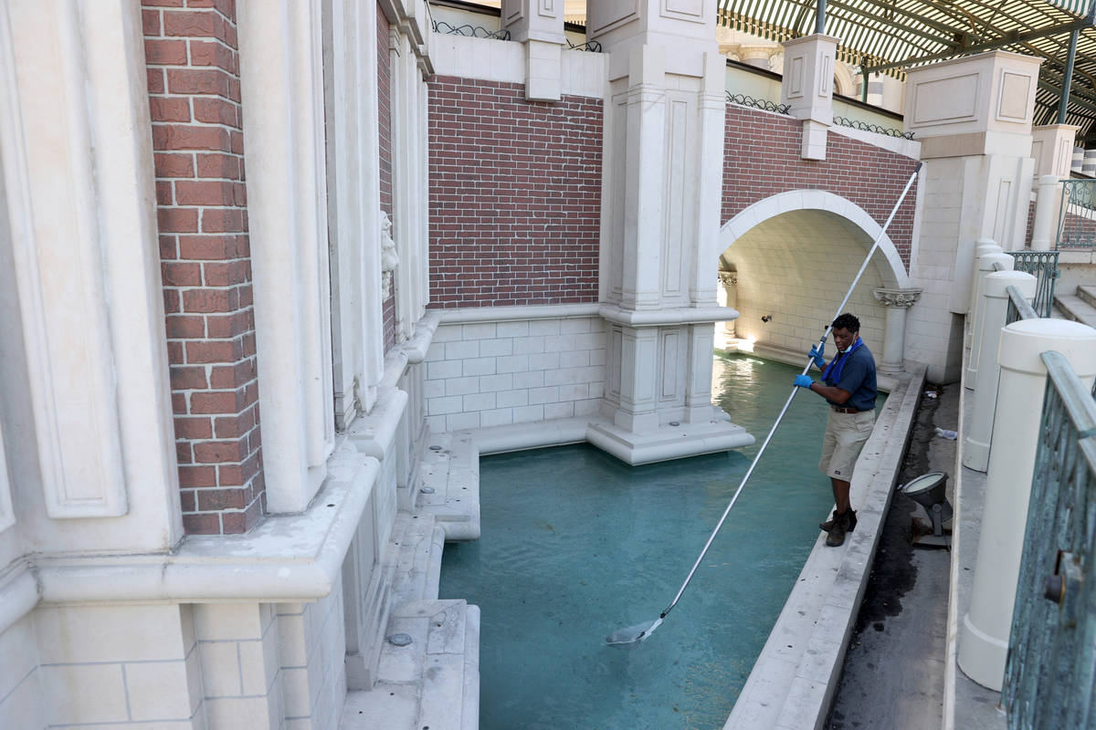 Pool maintenance worker Russell Bass cleans the outdoor canal at The Venetian on the Strip in L ...