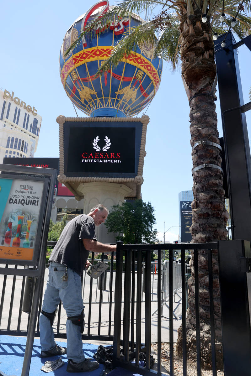 Joe Ray, and engineer at JRS Hospitality, paints railing at Beer Park at Paris Las Vegas on the ...