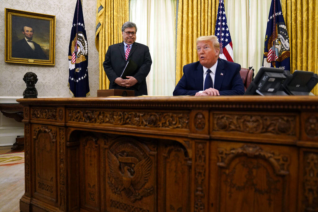 Attorney General William Barr listens as President Donald Trump speaks before signing an execut ...