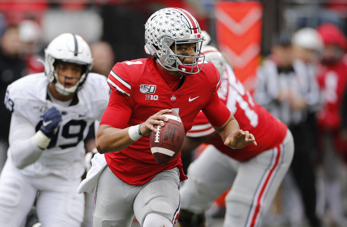Ohio State quarterback Justin Fields, right, looks for an open receiver as Penn State defensive ...