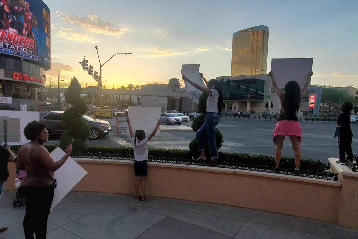 A handful of people protesting the death of George Floyd in Minneapolis wave signs Thursday, Ma ...