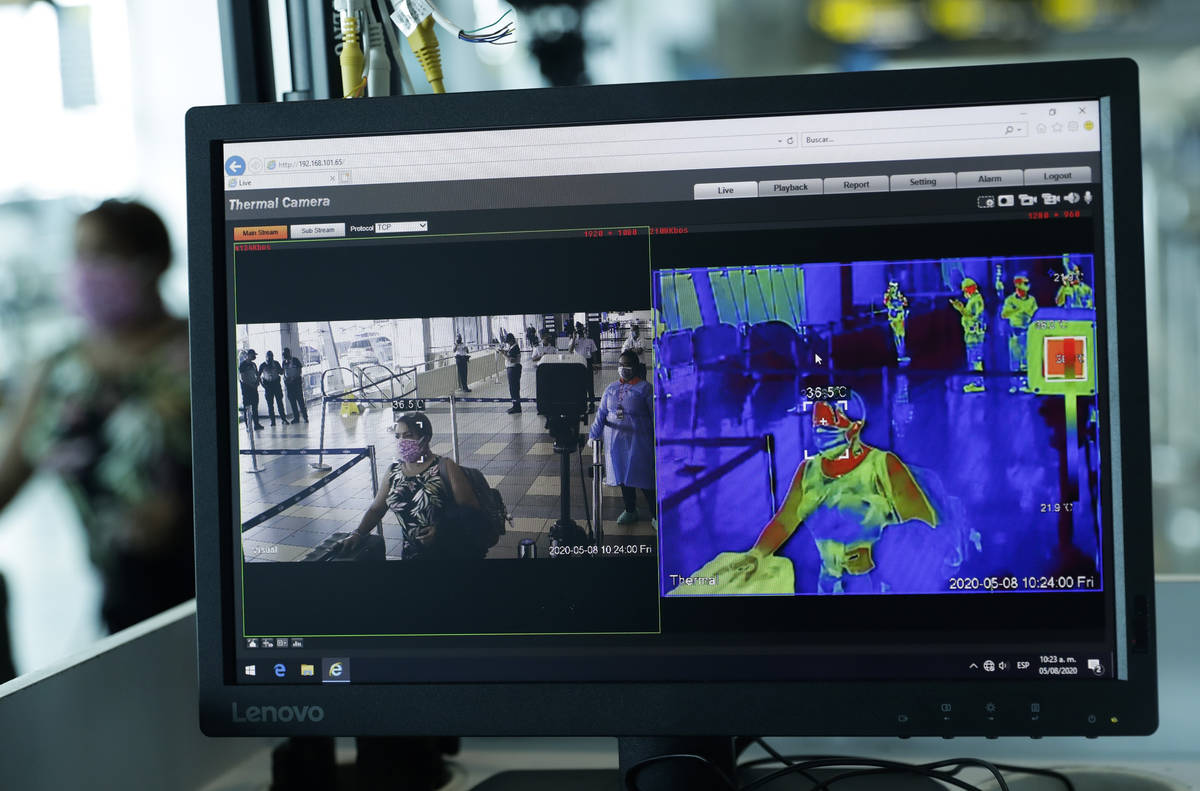 A thermal camera monitor shows the body temperature of a passenger on her way to boarding a hum ...