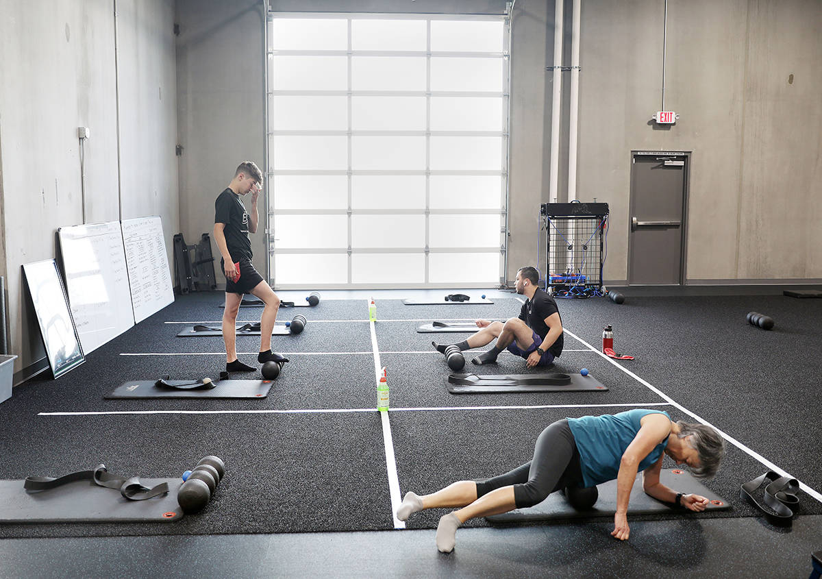 Members of The Gym Las Vegas stretch while following social distancing guidelines the first mor ...