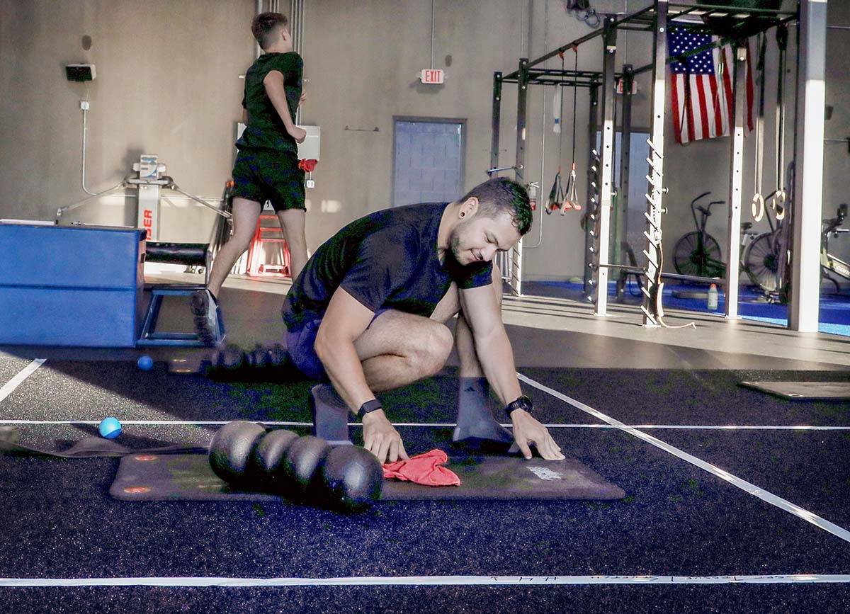 Brian Lee, member of The Gym Las Vegas, disinfects his mat, the first morning on the facility&# ...