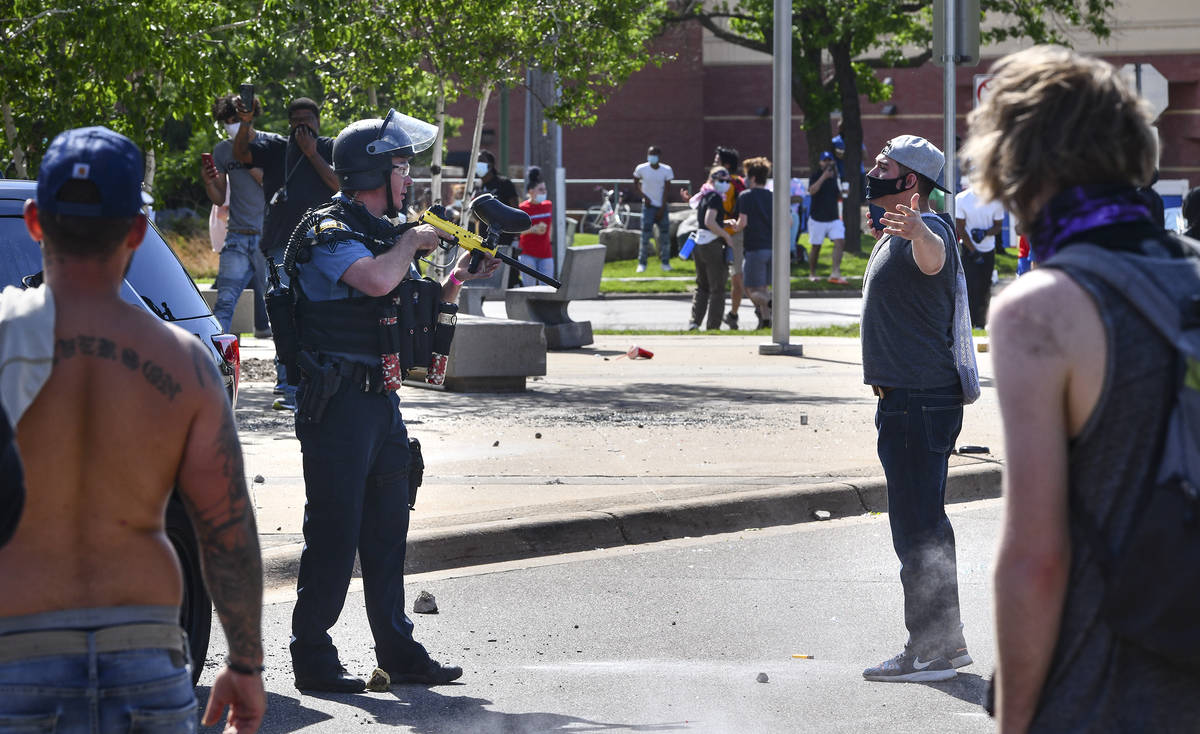 A St. Paul police officer, second from left, armed with a non-lethal paintball-style weapon, f ...