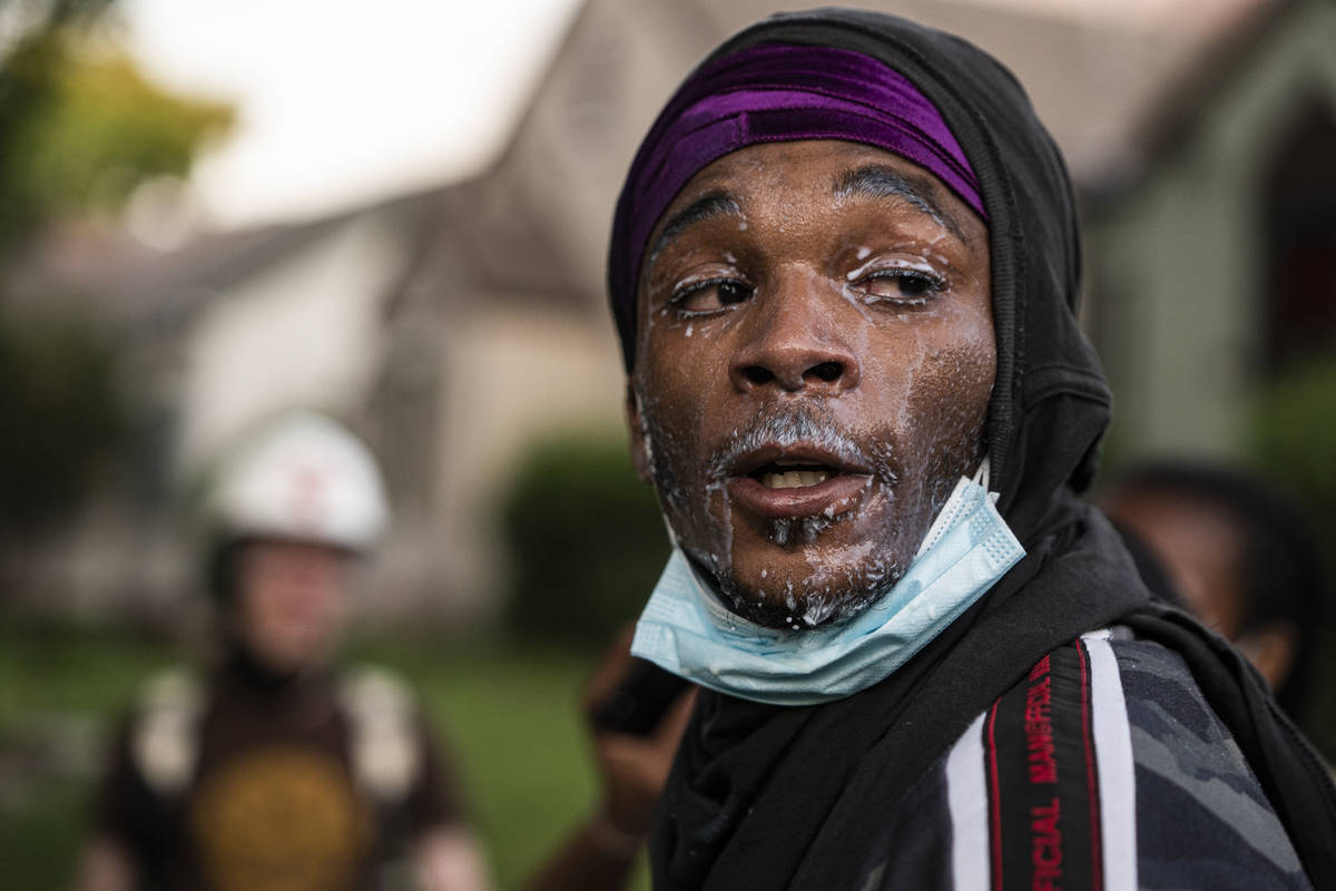 A protester used milk to mitigate tear gas as buildings near the Midway were either damaged or ...