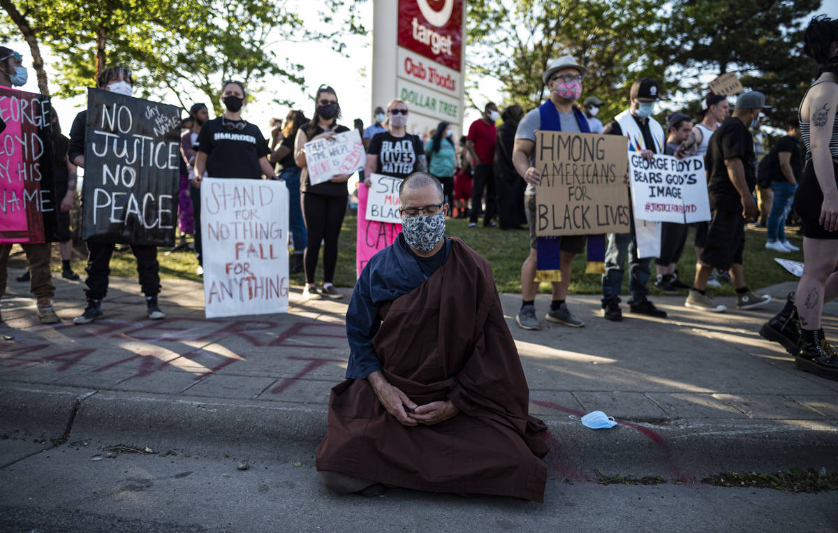 A person meditates near the Minneapolis police 3rd Precinct on Thursday, May 28, 2020, the thir ...