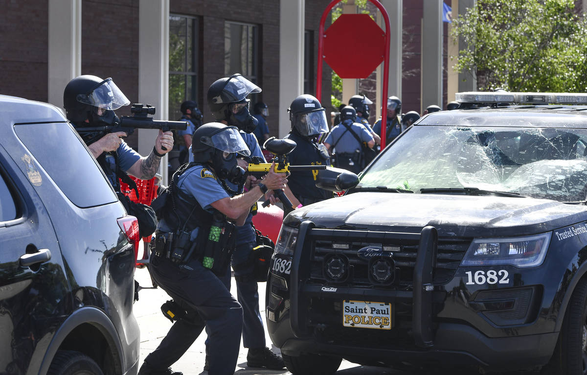 St. Paul police officers aim non-lethal weapons into a crowd near University Avenue West Thursd ...