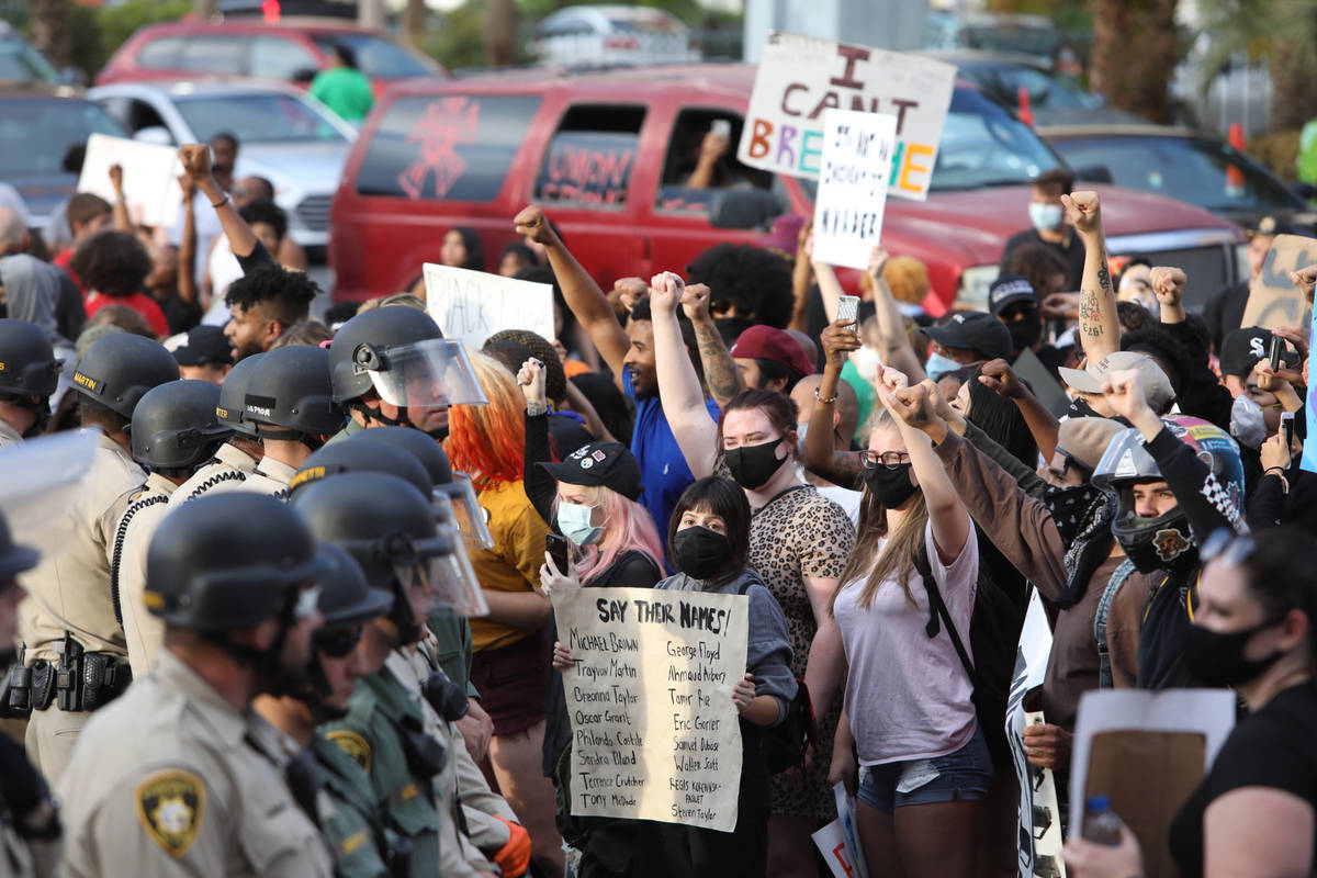 Demonstrators face off against police while demanding justice for George Floyd along the Las Ve ...