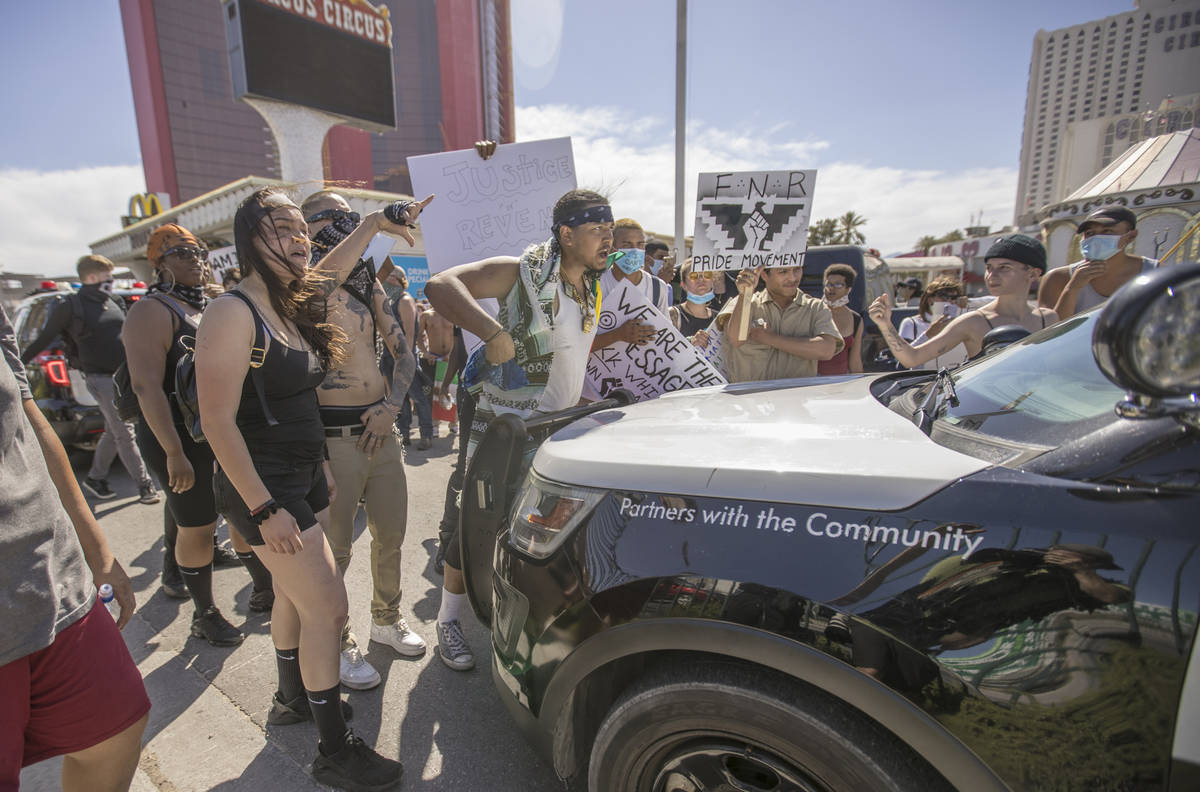 People yell at Las Vegas Police in their vehicle during a Black Lives Matter protest and march ...