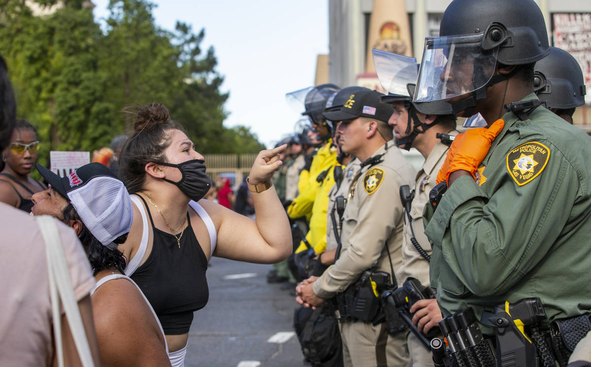 A protestor yells at a Las Vegas Police officer as they are lined up to block progress along th ...
