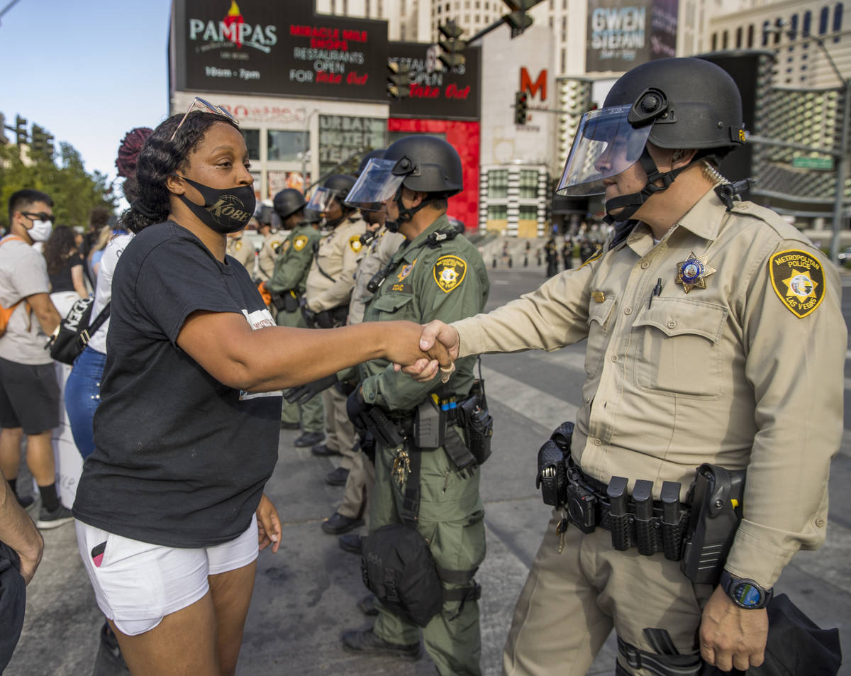 A protestor shakes the hands of each Las Vegas Police officer lined up to block progress down t ...