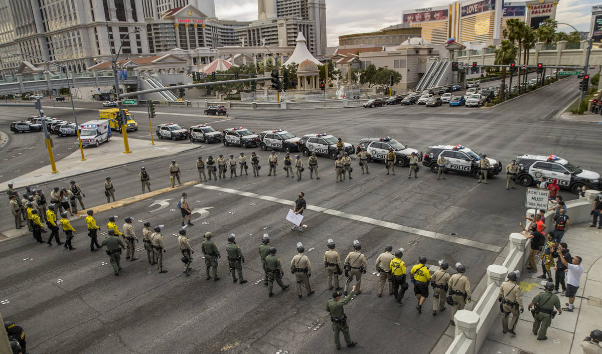Two protestors are boxed in as Las Vegas Police officers advance up the Las Vegas Strip at W. F ...
