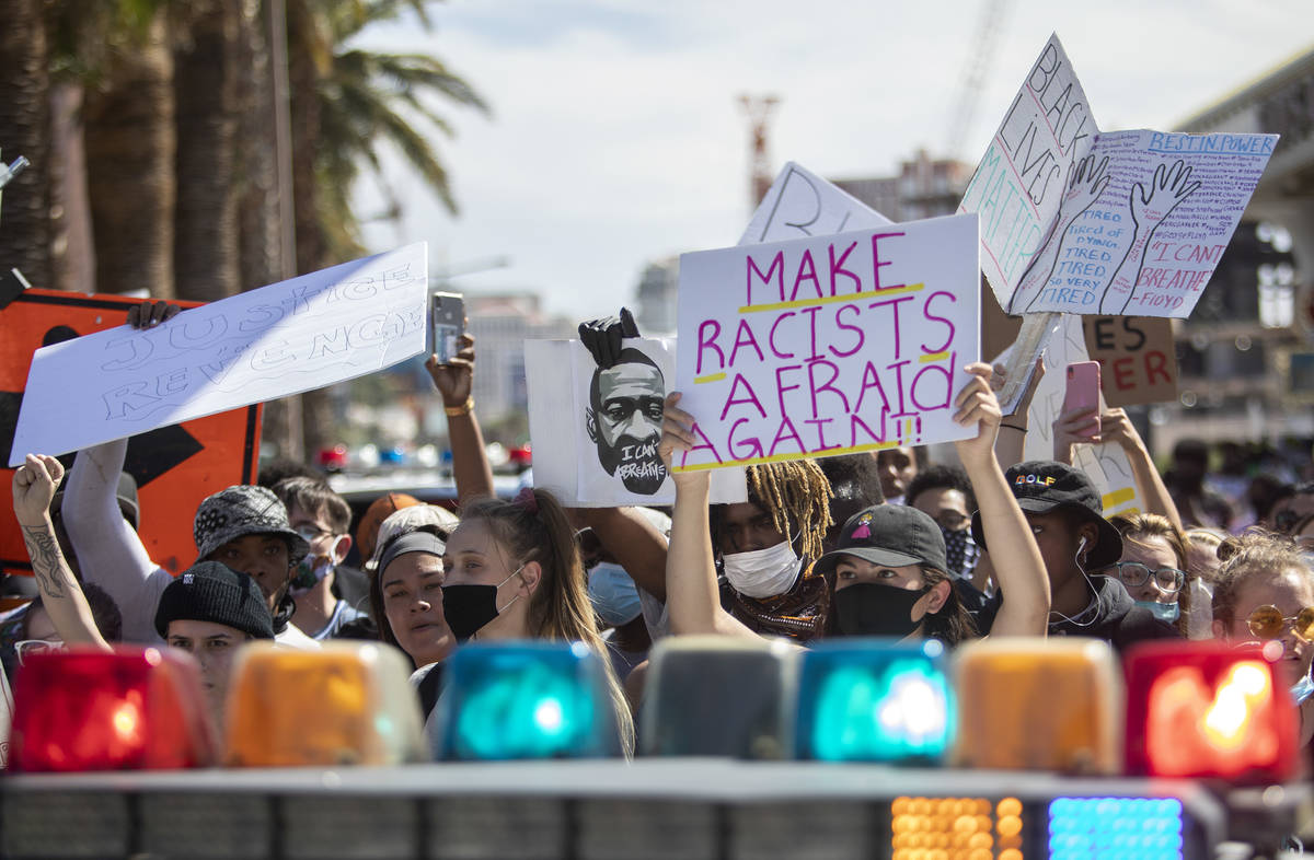 Supporters and members of the Black Lives Matter movement stand before a police vehicle protest ...