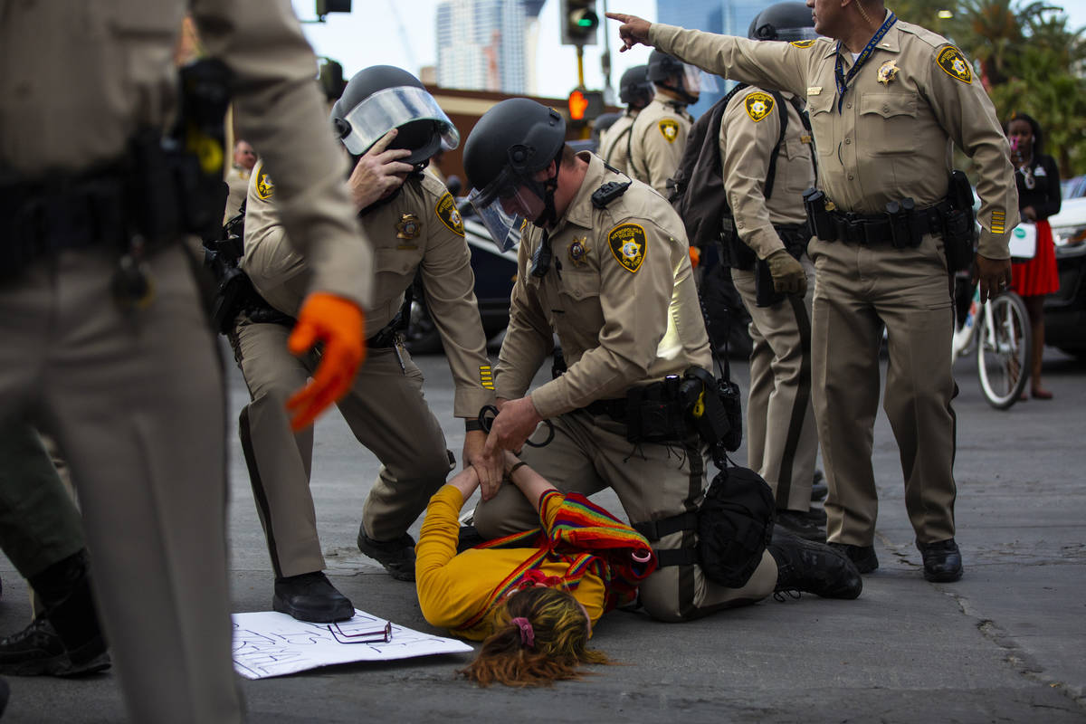 Police arrest a demonstrator as people gather to demand justice for George Floyd along the Las ...