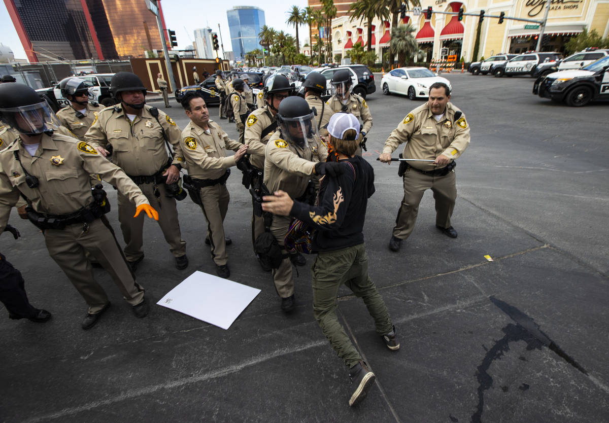 Police arrest a demonstrator as people gather to demand justice for George Floyd along the Las ...