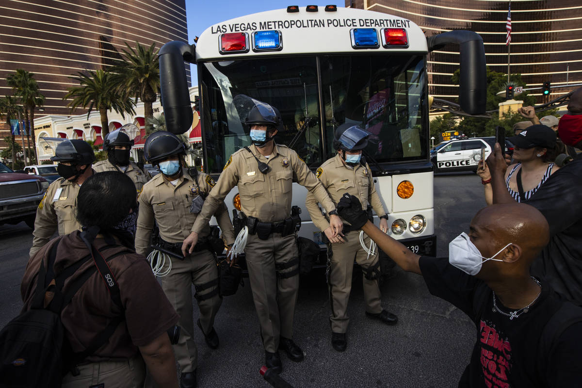 Demonstrators face off against police while demanding justice for George Floyd along the Las Ve ...