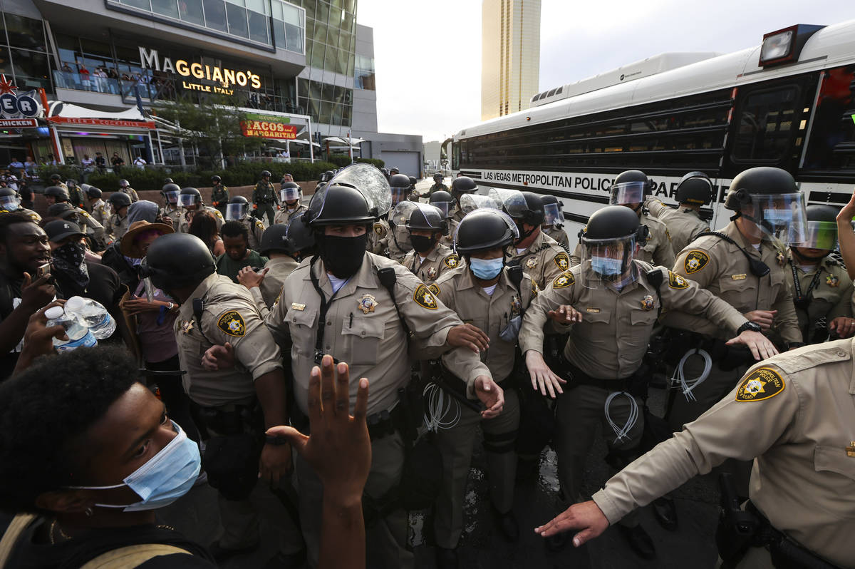 Demonstrators face off against police while demanding justice for George Floyd along the Las Ve ...