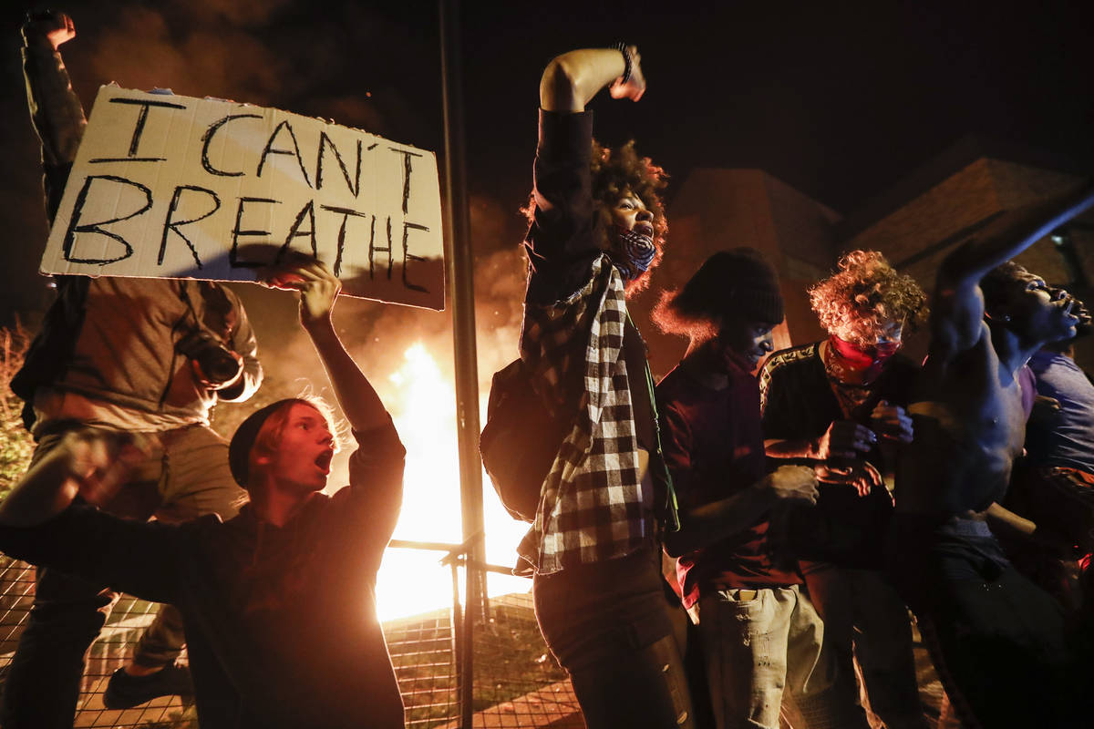Protestors demonstrate outside of a burning Minneapolis 3rd Police Precinct, Thursday, May 28, ...