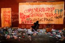 A protestor sprays graffiti on a wall near the Minneapolis 3rd Police Precinct, Thursday, May 2 ...