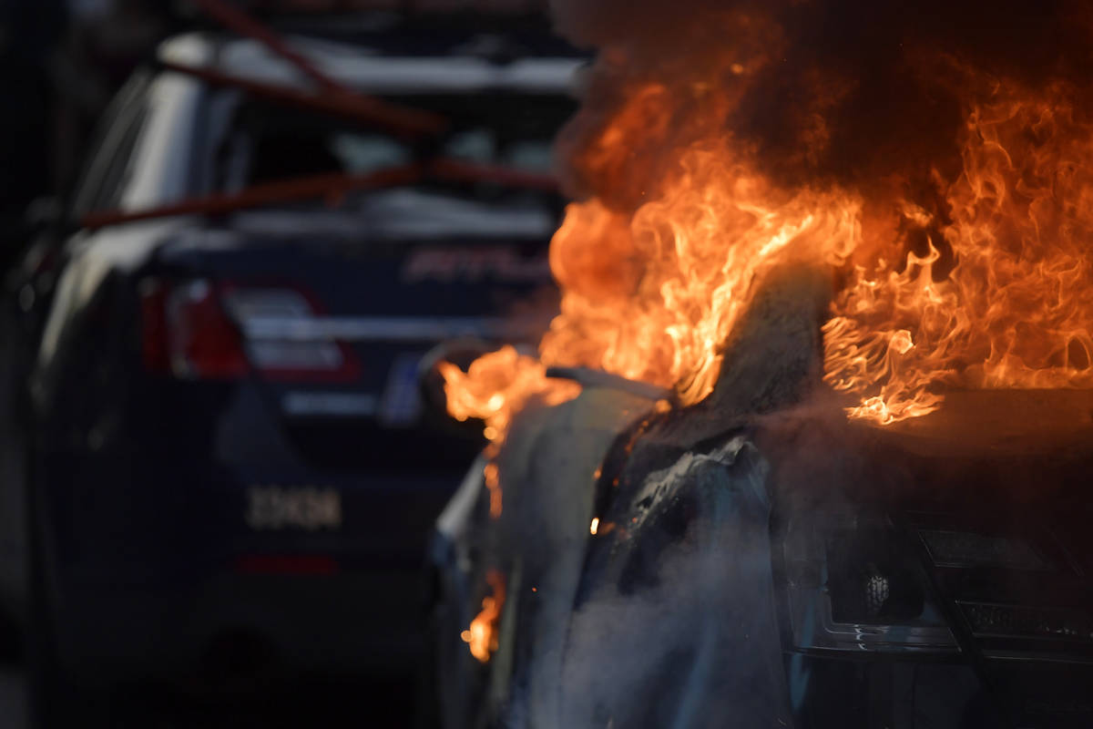 An Atlanta Police Department vehicle burns during a demonstration against police violence, Frid ...