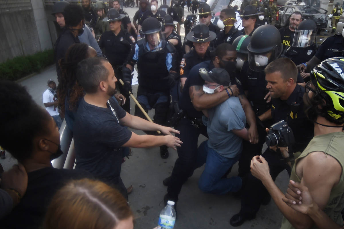 Police officers and protesters clash near CNN center, Friday, May 29, 2020 in Atlanta. The prot ...