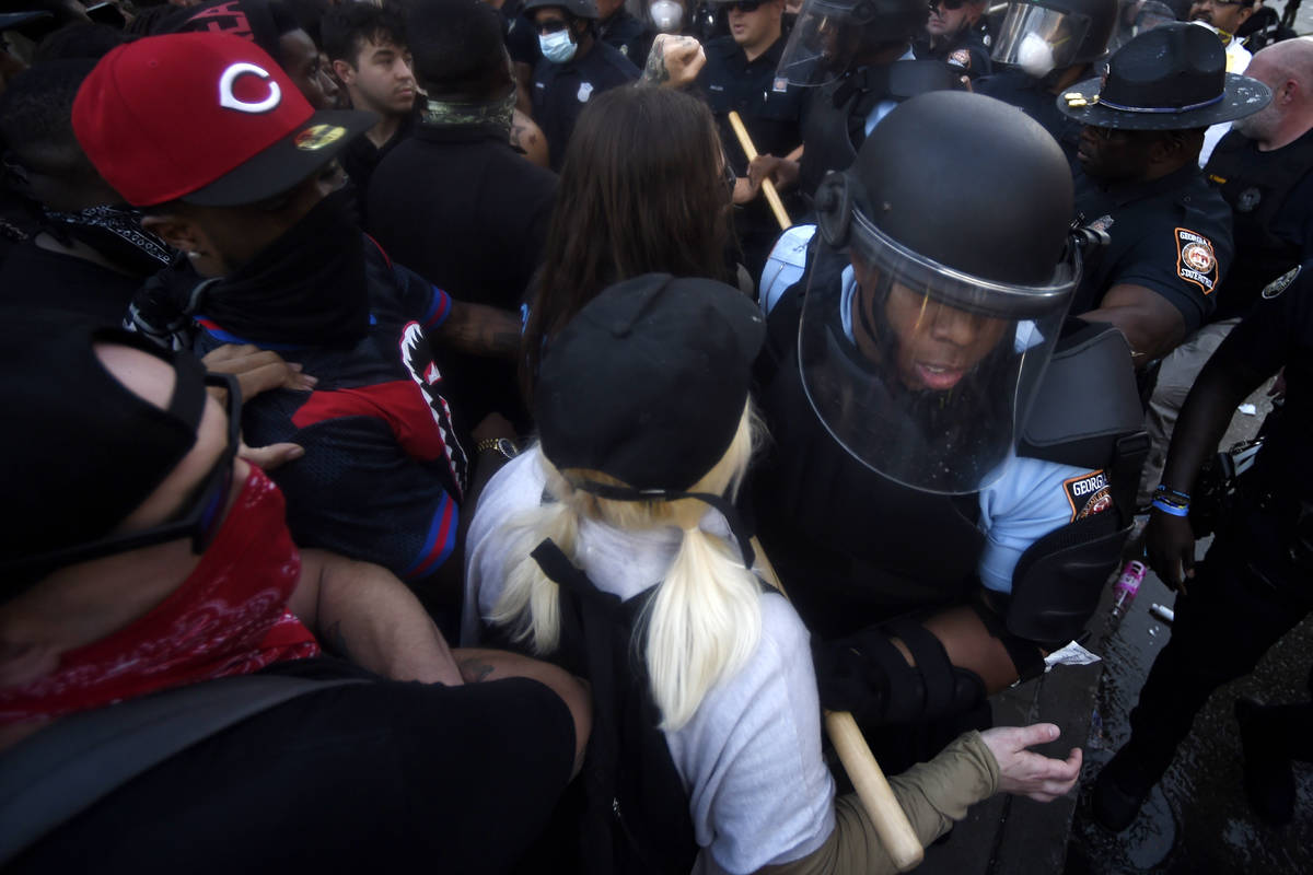 Police officers and protesters clash near CNN center, Friday, May 29, 2020 in Atlanta. The prot ...