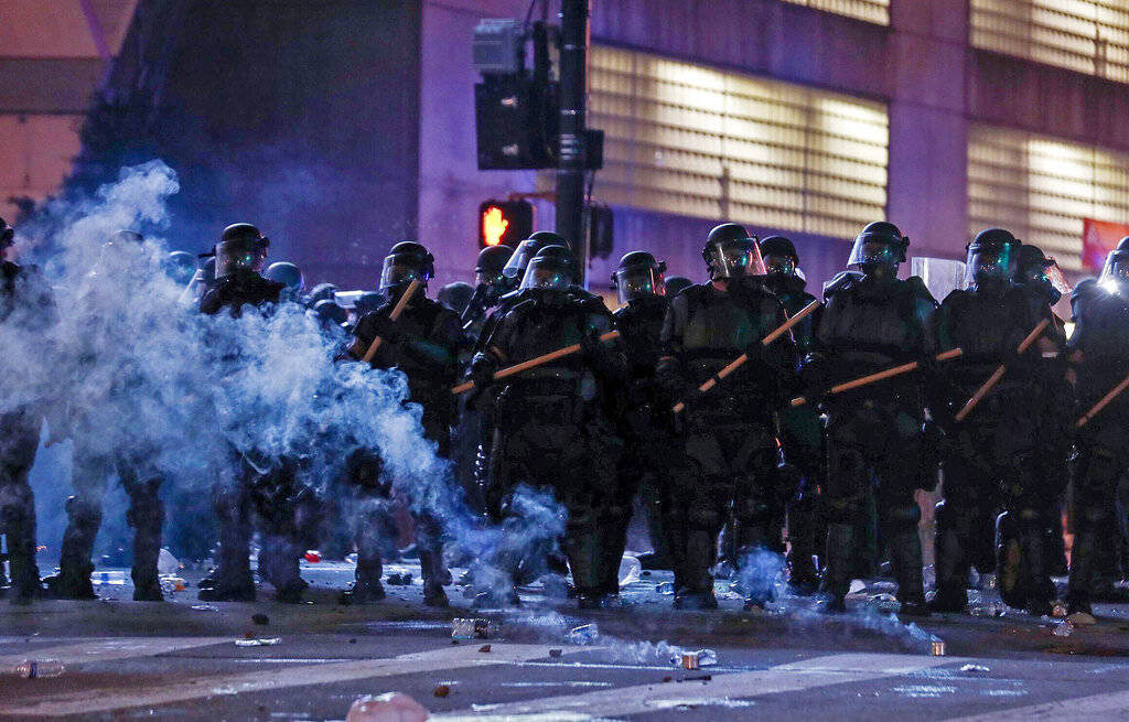 Police in riot gear form a line near the Centennial Olympic Park and CNN center where some conf ...