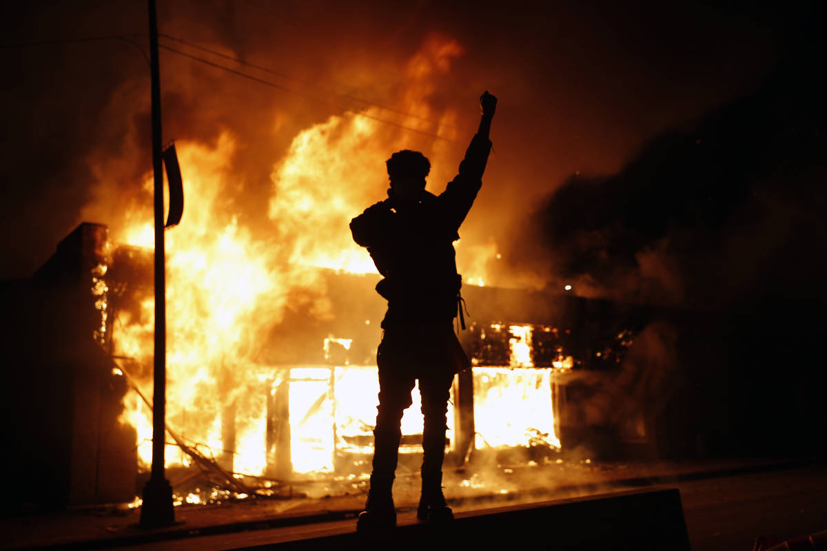 In this May 29, 2020, photo, a check-cashing business burns during protests in Minneapolis. Pro ...