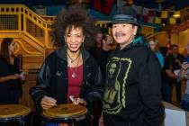 Carlos Santana and Cindy Blackman Santana, shown signing a bongo drum, appear at a Discovery Ch ...