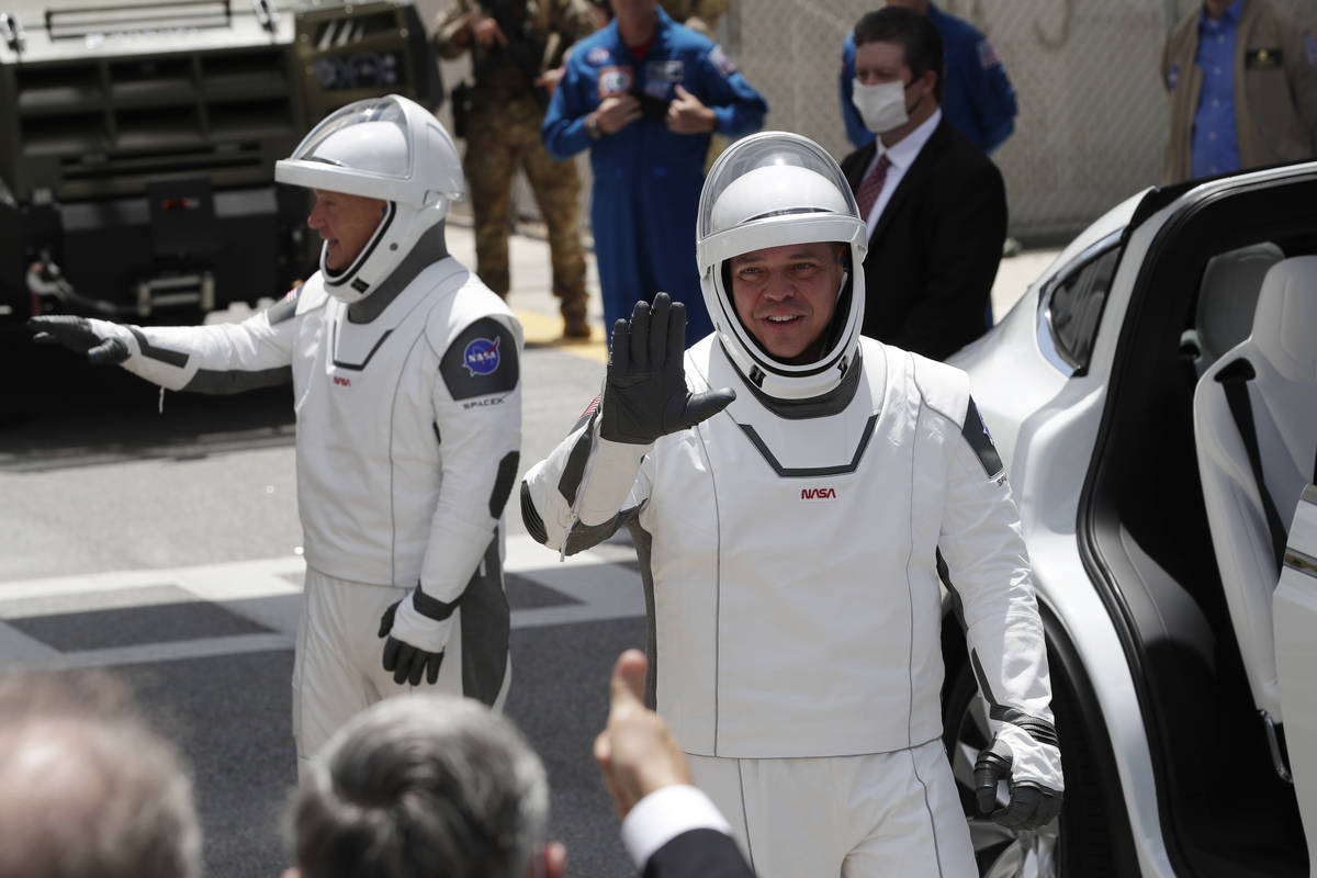 NASA astronauts Douglas Hurley, left, and Robert Behnken wave as they exit the Neil A. Armstron ...