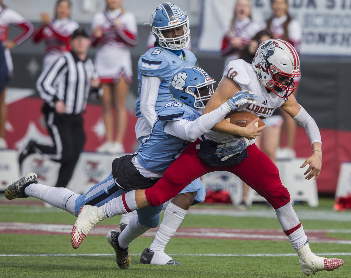 Liberty junior quarterback Daniel Britt (18) breaks a big run past Centennial junior Tyrone McC ...