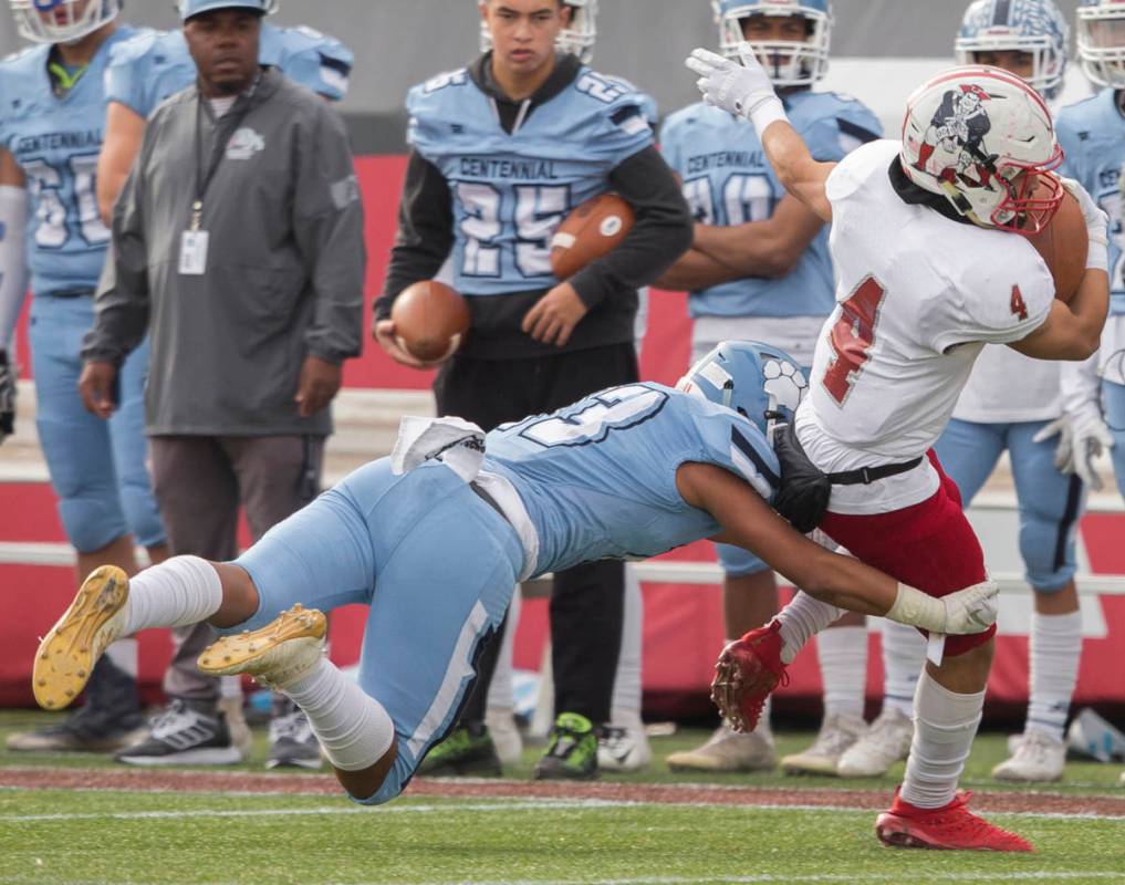 Liberty senior running back Edward Gastelum (4) turns up field past Centennial senior Ronaven M ...
